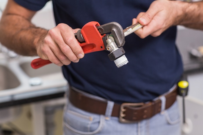 plumber holding a pipe wrench plumbing tool